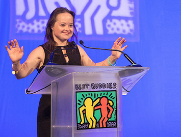 Female Best Buddies participant speaking at a podium at a Best Buddies event