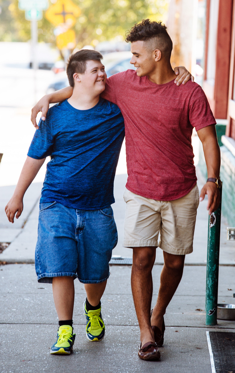 Best Buddies Volunteers standing back to back and smiling