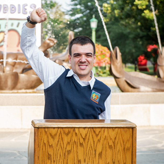 A Best Buddies Leadership Development participant speaks from a wooden podium.