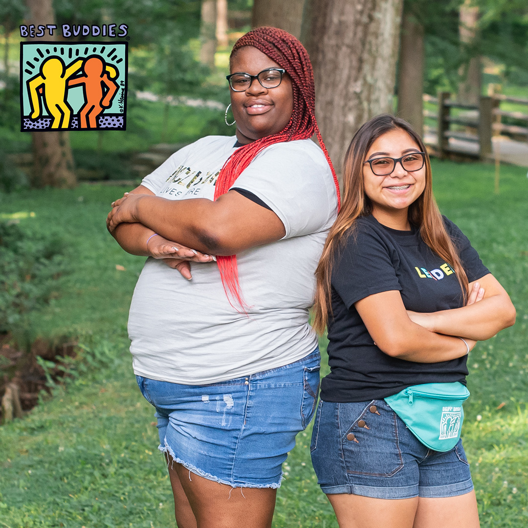 Female Buddy Pair standing back to back and smiling