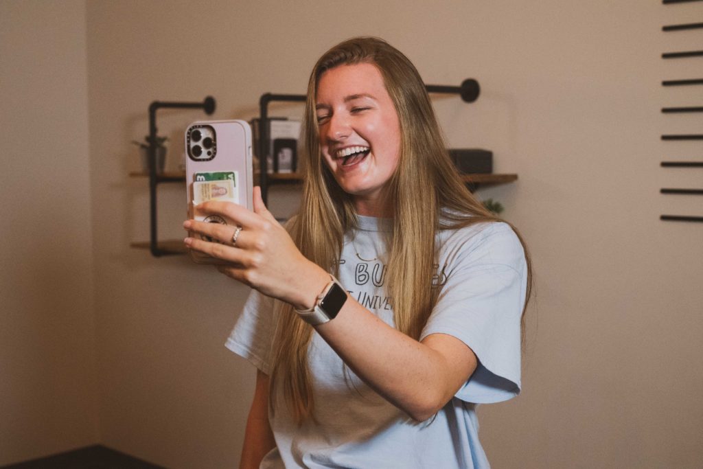 Young woman smiling and looking at her phone