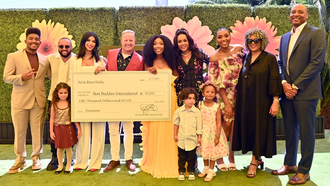 Best Buddies Ambassador Joshua Felder, Wassim ‘Sal’ Slaiby, Rima Fakih Slaiby, David Quilleon, Brandy, Vivica A. Fox, Sy'Rai Smith, and Sonja Norwood presenting a $50,000 donation to Best Buddies International.