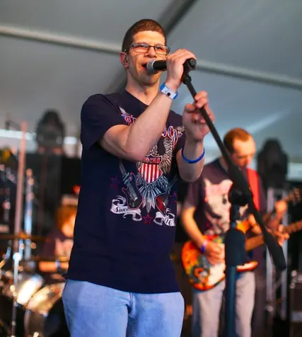 Bret Fleming singing on stage at a Best Buddies event