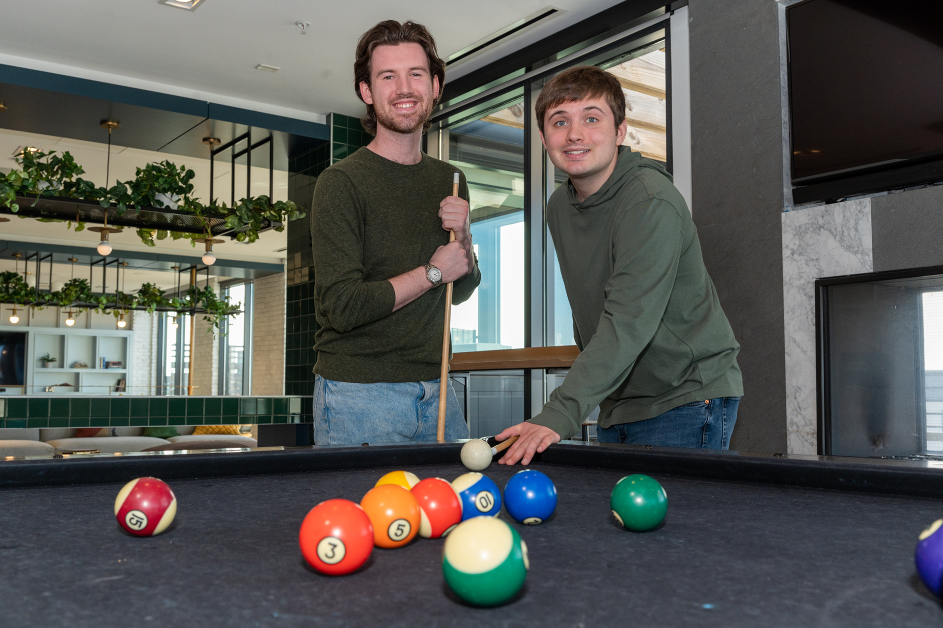 Two Best Buddies male Living Program participants are playing Pool.