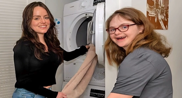 Two cheerful female participants of the Living Program share smiles as they collaborate on laundry tasks, fostering independence and camaraderie.