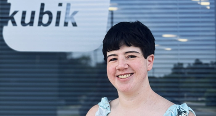 Woman smiling outside her workplace.