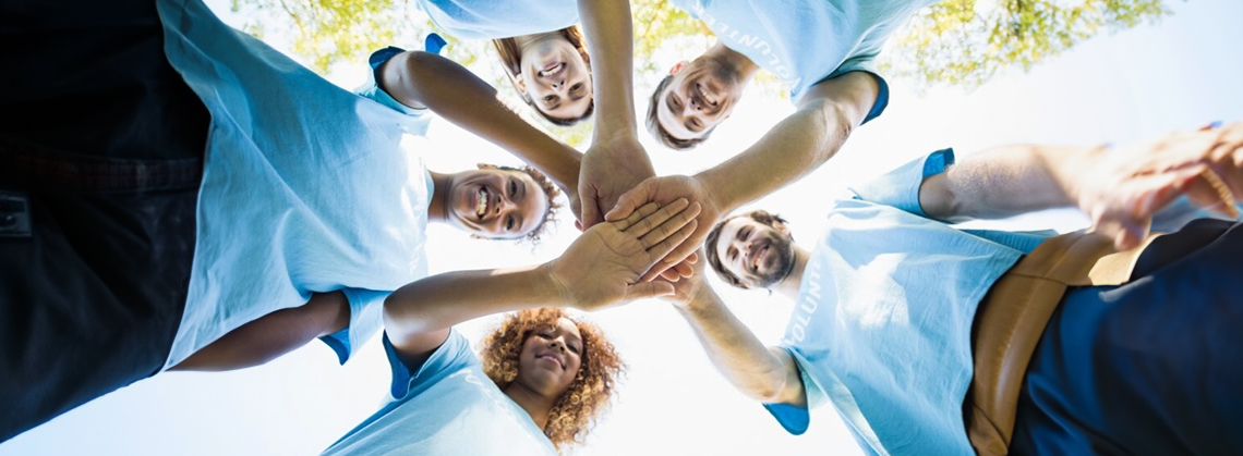 Five people joining hands to show their support for one another.